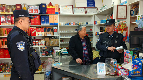 图为民警对商铺报警器进行检查.jpg